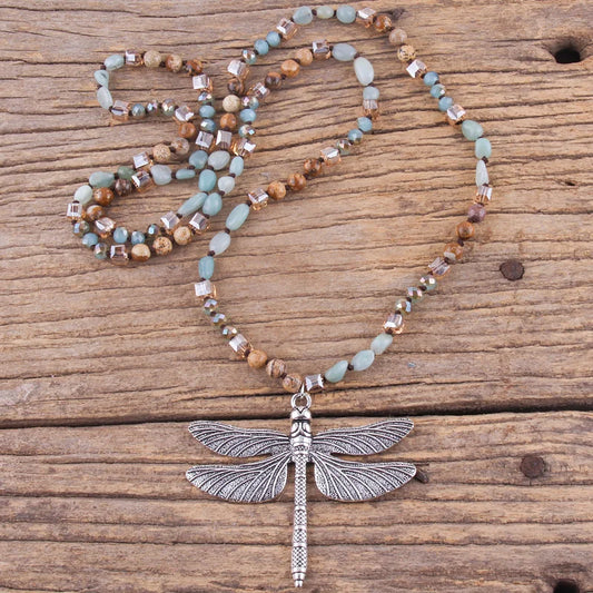 Beaded necklace with a dragonfly pendant on a wooden surface