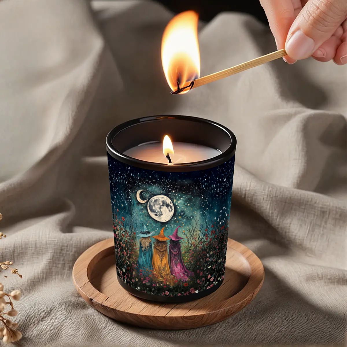 Candle being lit with a match, featuring a decorative candle holder with a celestial design.