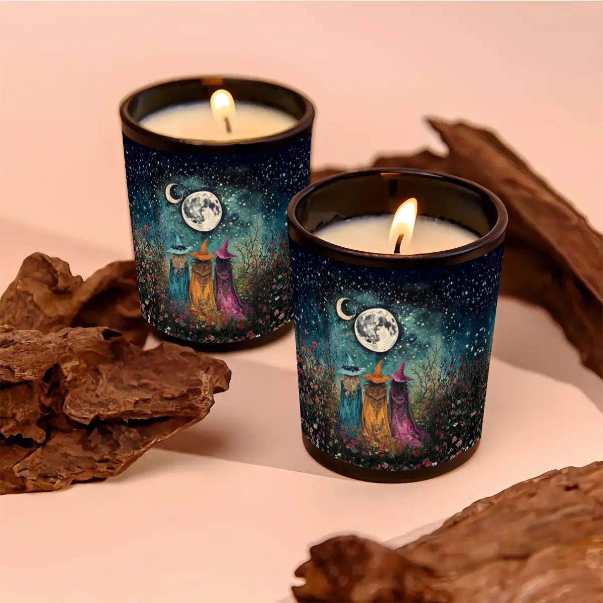 Two lit candles in decorative tins with witch designs on a pink background