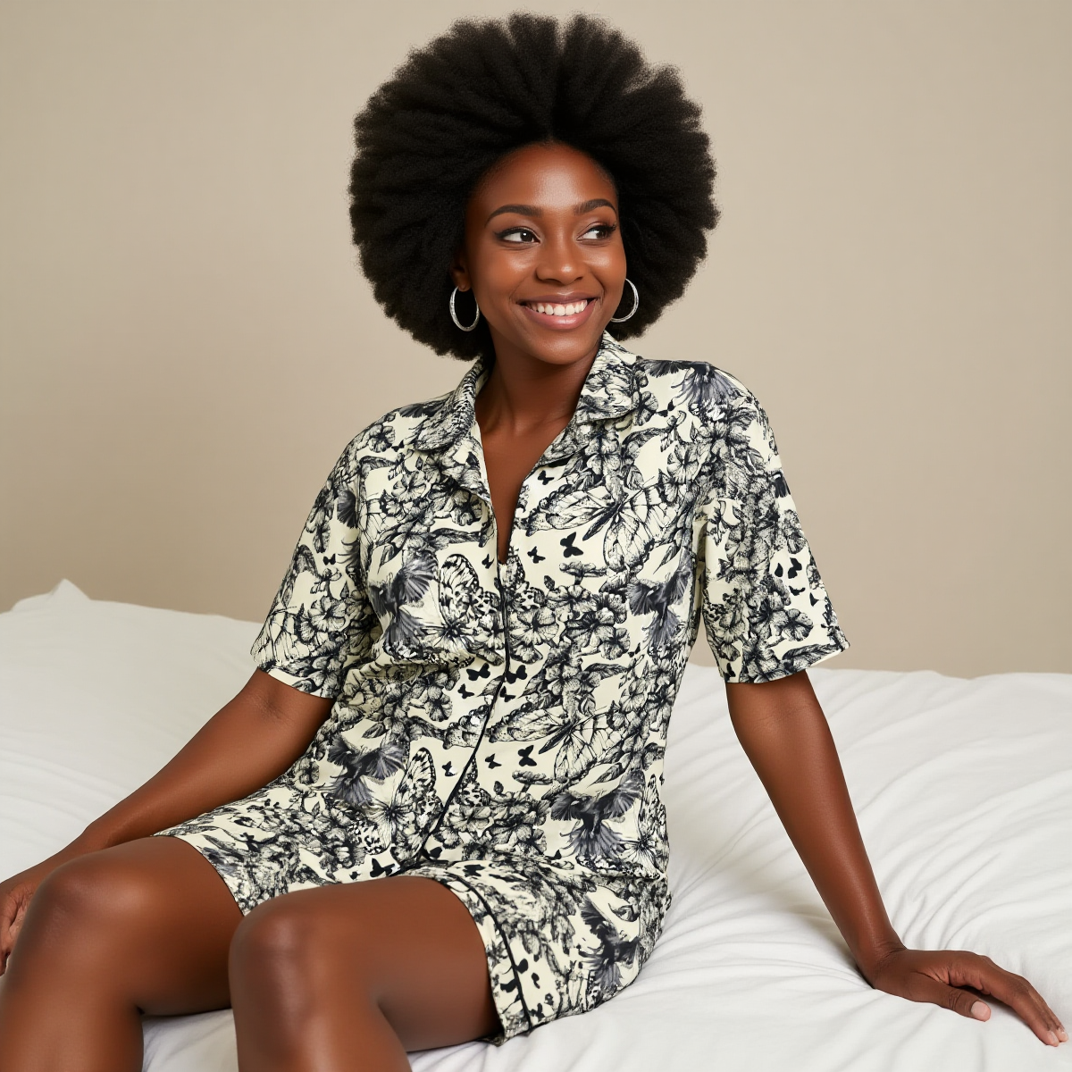 Woman wearing a patterned outfit sitting on a white couch against a beige wall.