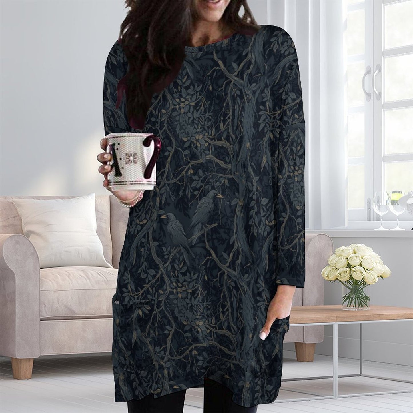 Woman wearing a dark patterned dress holding a mug in a living room.
