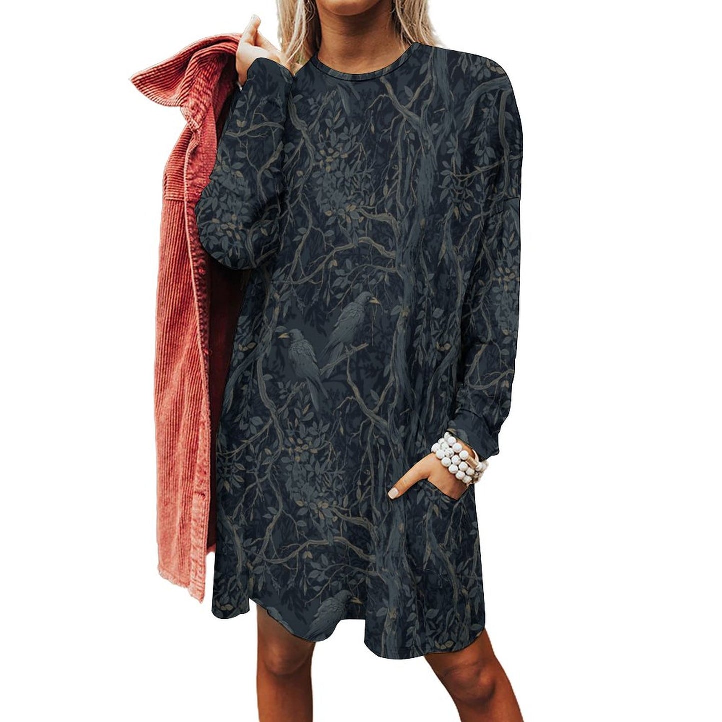 Woman wearing a dark patterned dress with a pink jacket on a white background