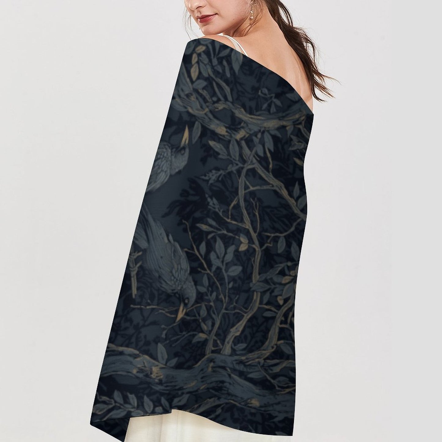 Woman wearing a dark strapless dress with a floral pattern on a light gray background