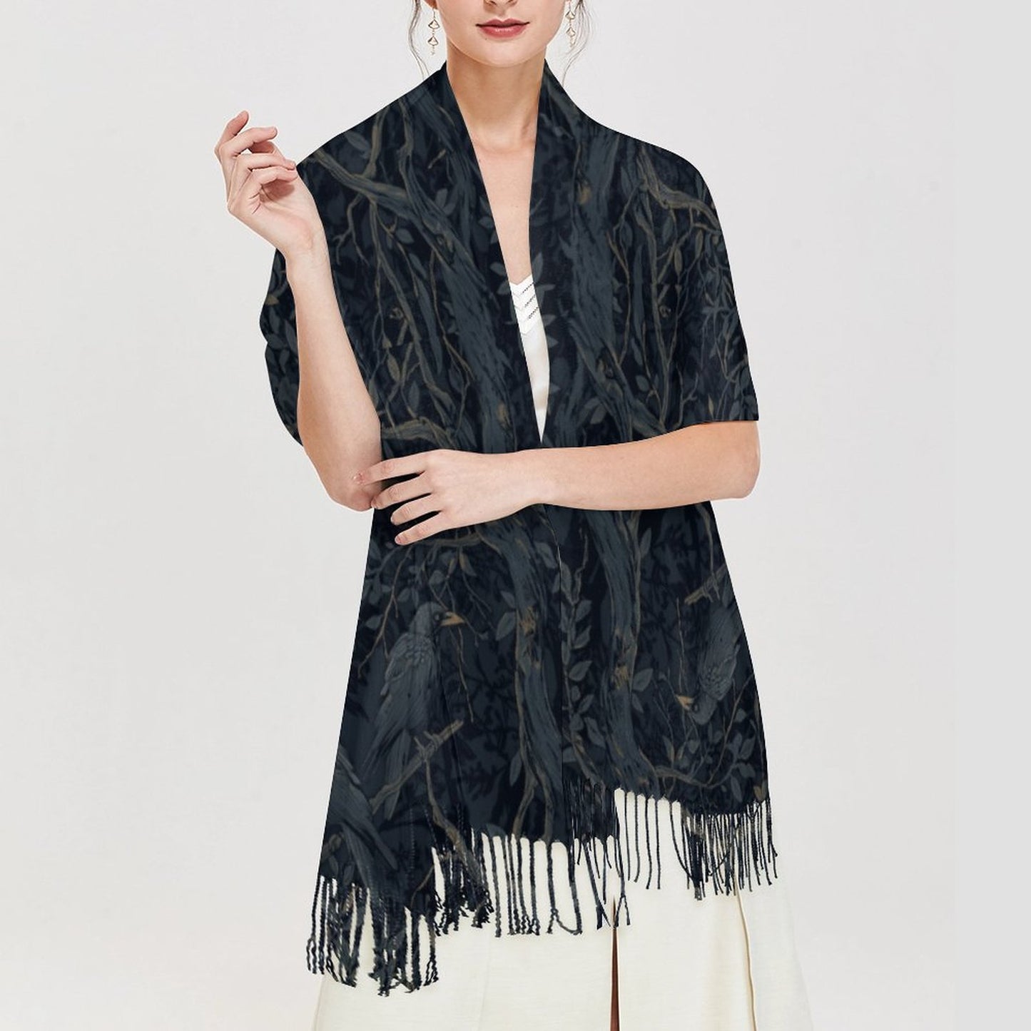 Woman wearing a black patterned scarf with fringe on a white background
