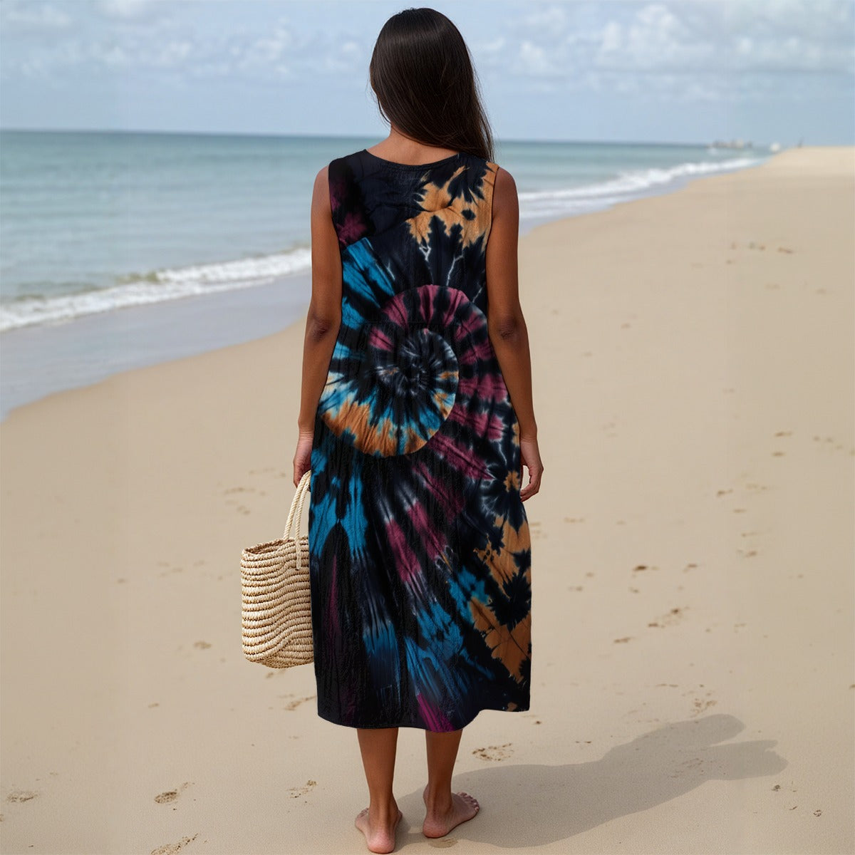 Woman in a tie-dye dress standing on a beach