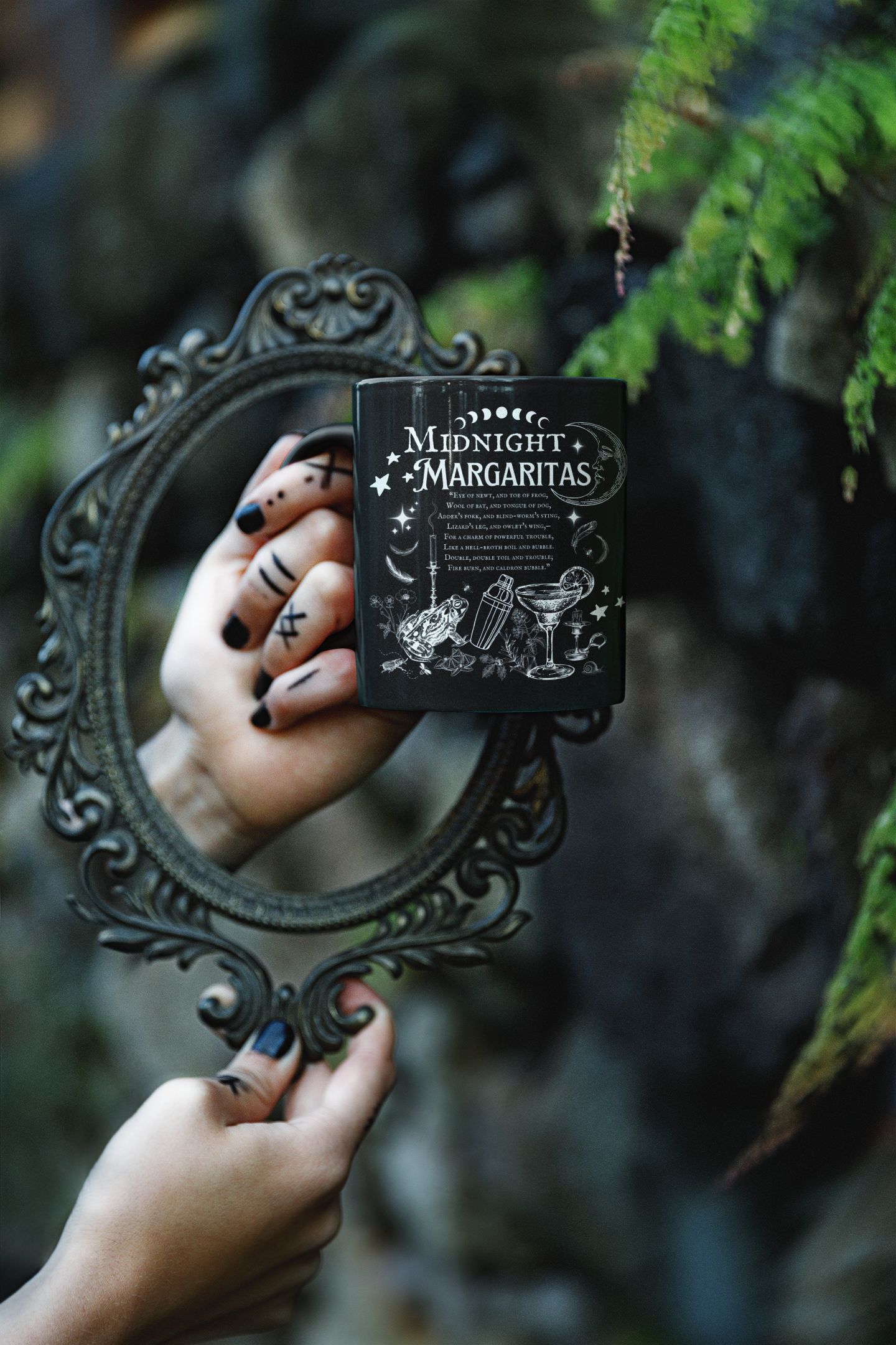 Hand holding a mirror with a 'Midnight Margaritas' menu card in a forest setting