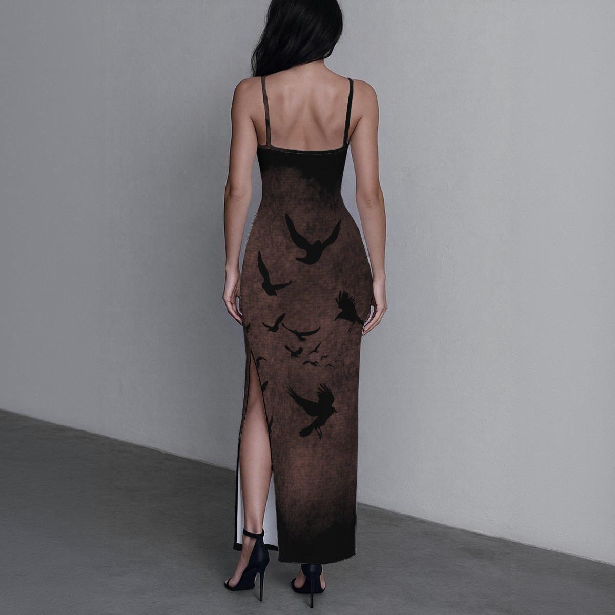 Woman wearing a long, dark dress with bird patterns on a plain background