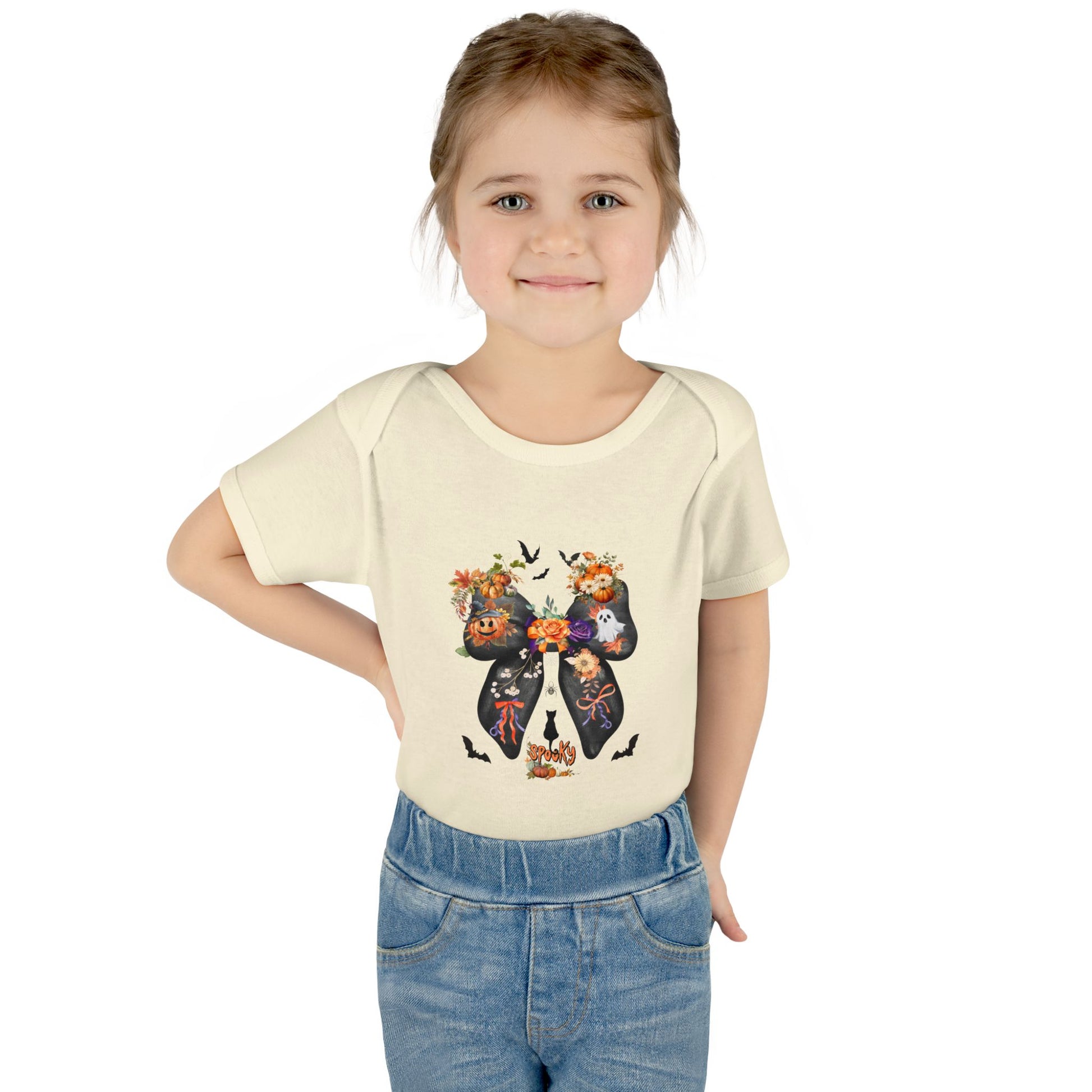 Young girl wearing a cream t-shirt with a colorful bow design on a white background