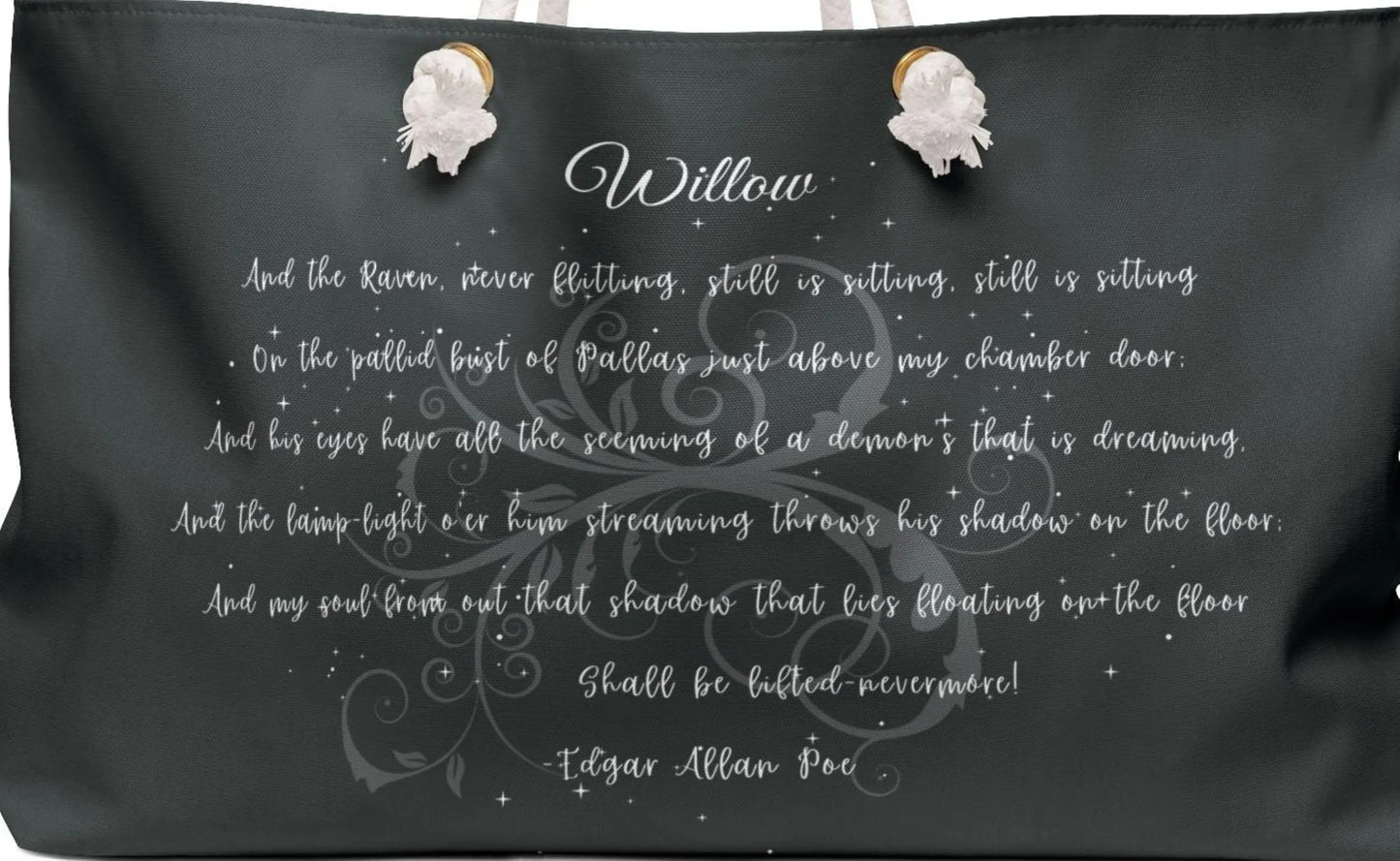 Black pillow with white text and decorative elements on a plain background