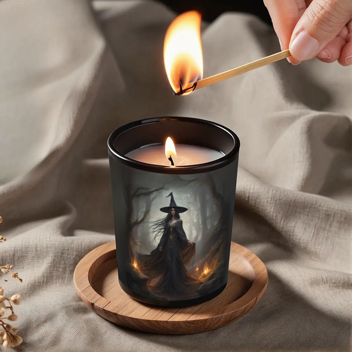 Candle being lit with a match, featuring a witch design on the candle.