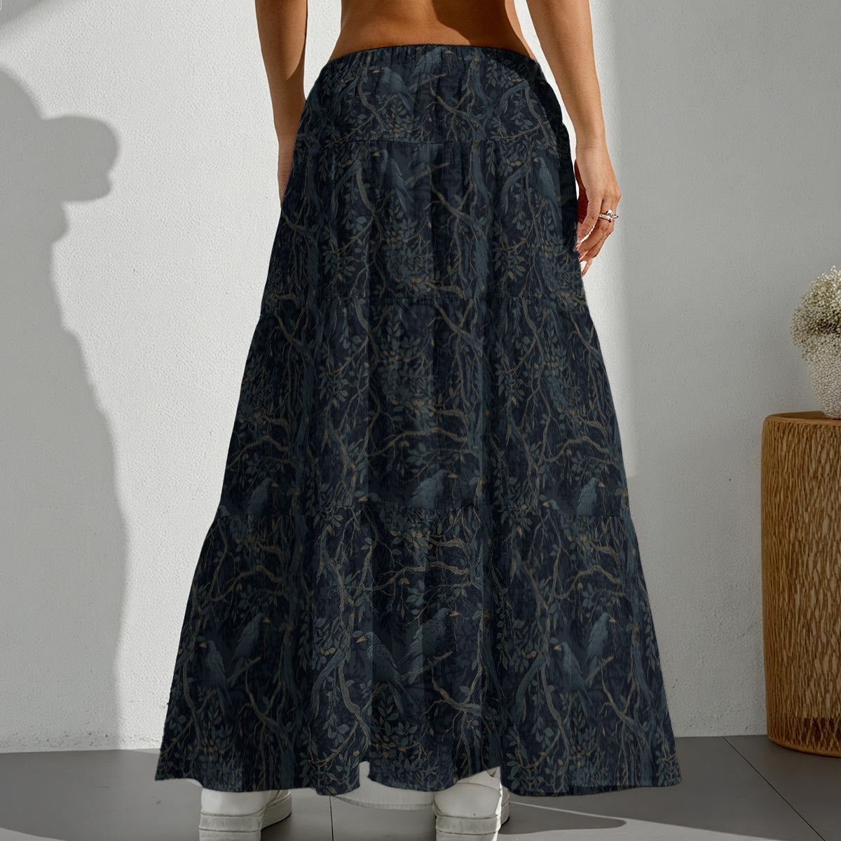 Person wearing a long dark blue patterned skirt against a plain background