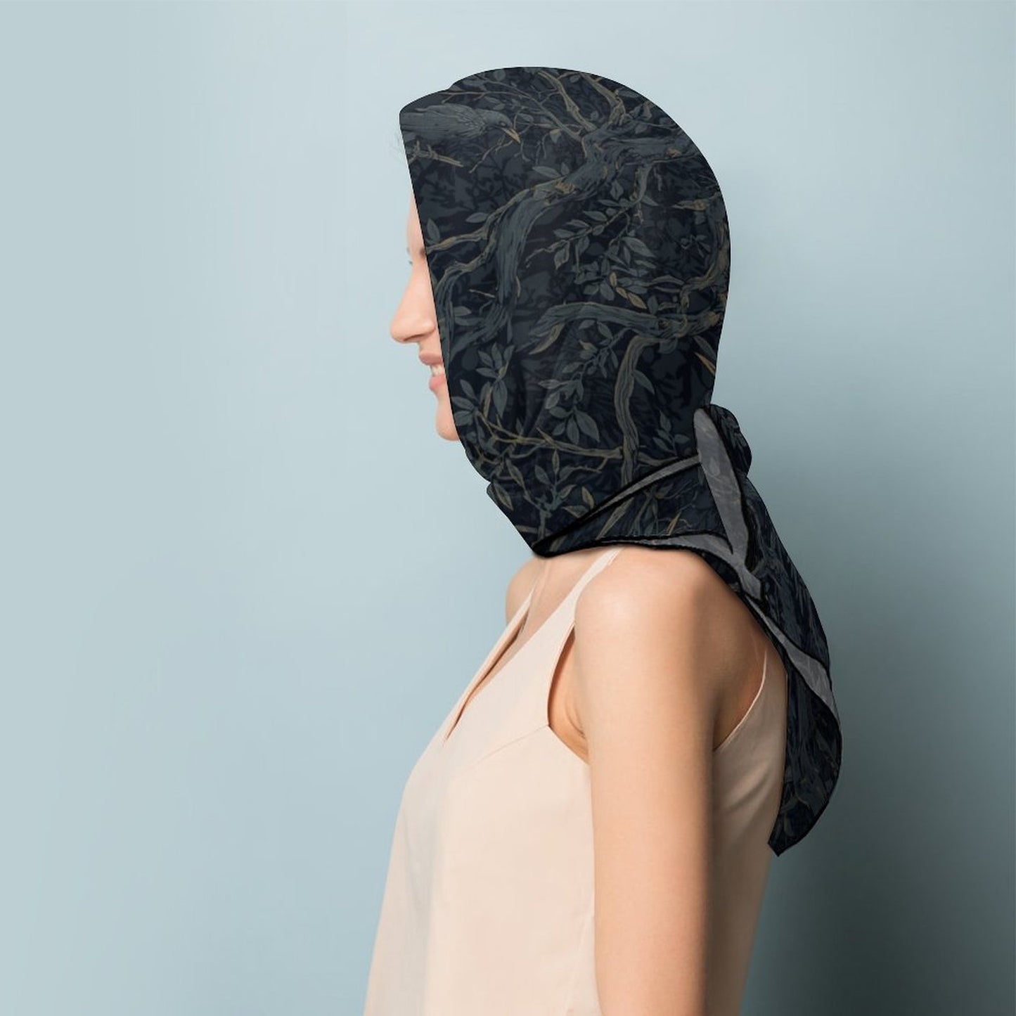 Person wearing a black floral patterned headscarf against a light blue background