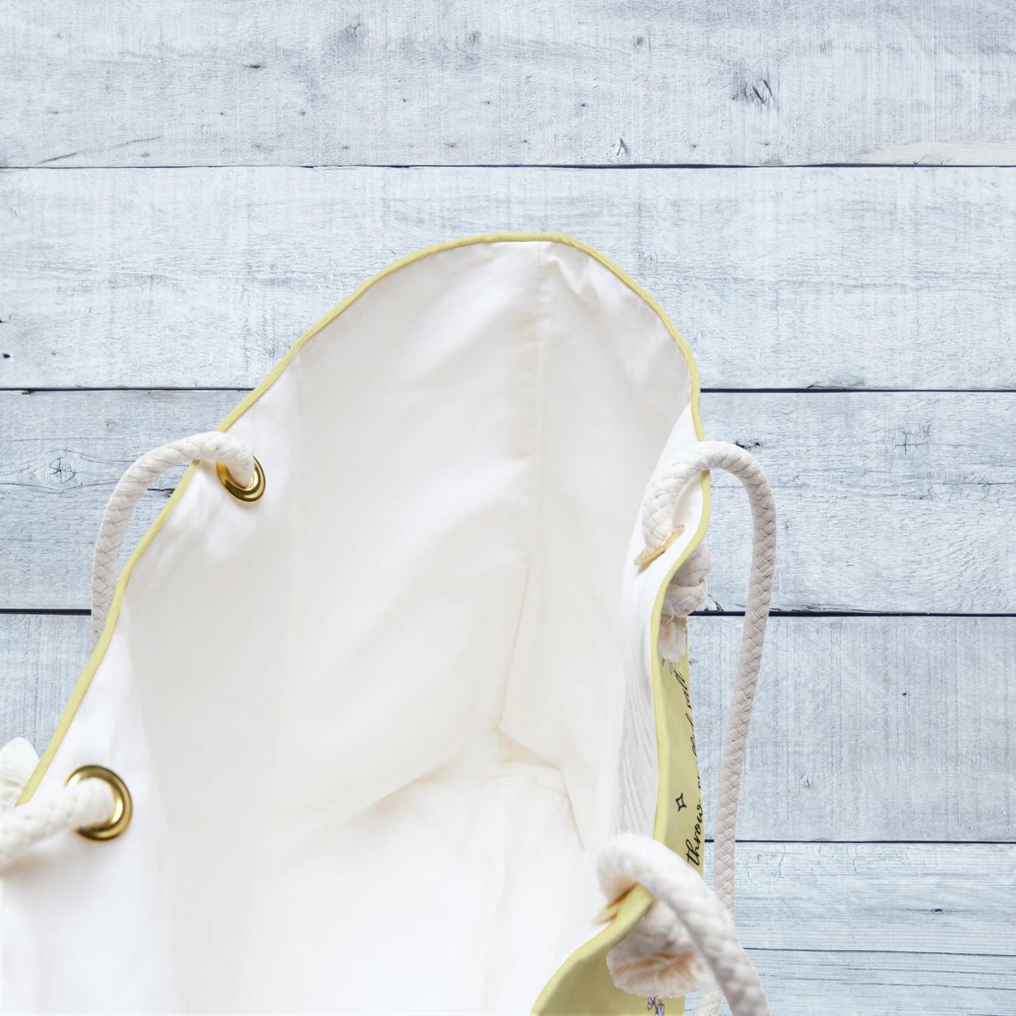 White bag with gold accents on a light wooden surface