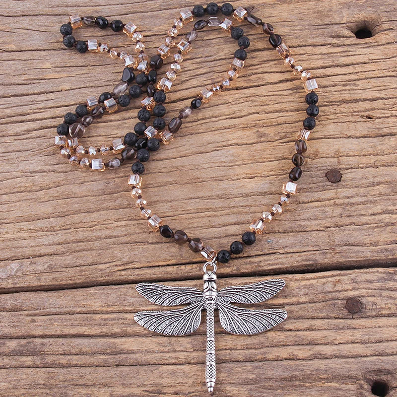 Necklace with dragonfly pendant on a wooden surface