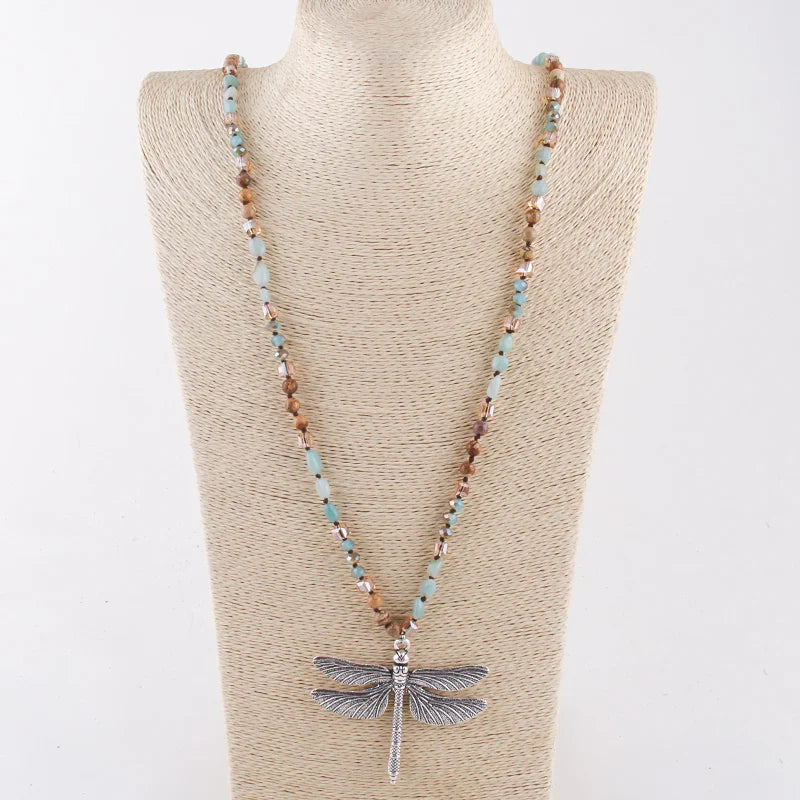 Necklace with dragonfly pendant on a mannequin bust against a white background