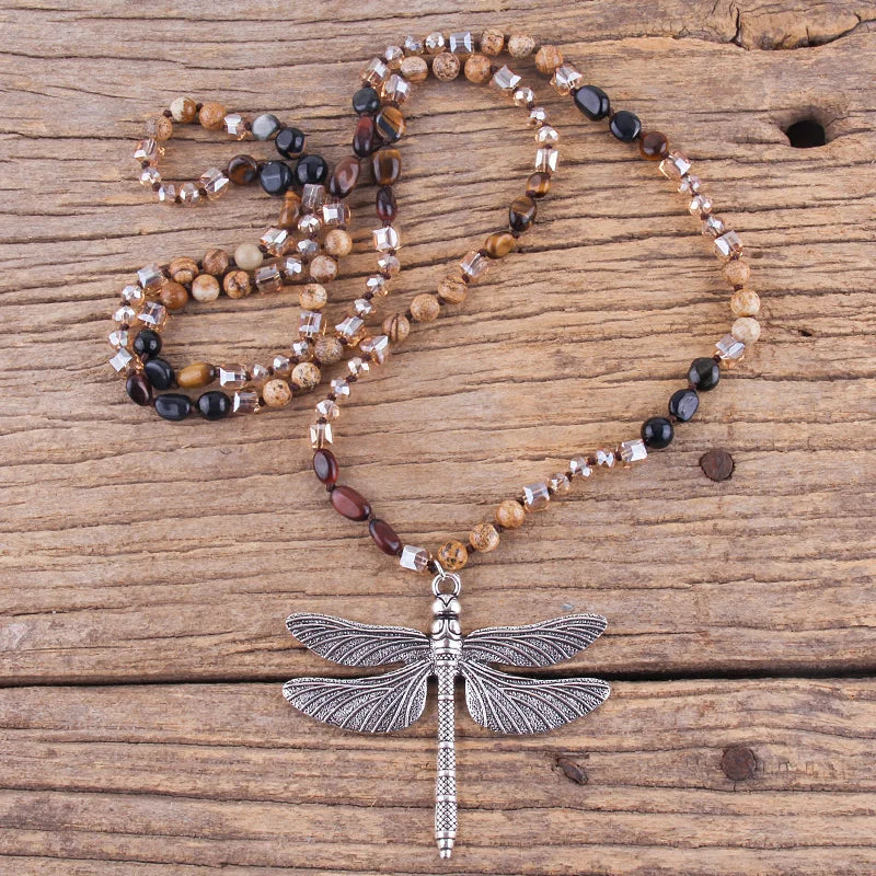 Beaded necklace with a dragonfly pendant on a wooden surface