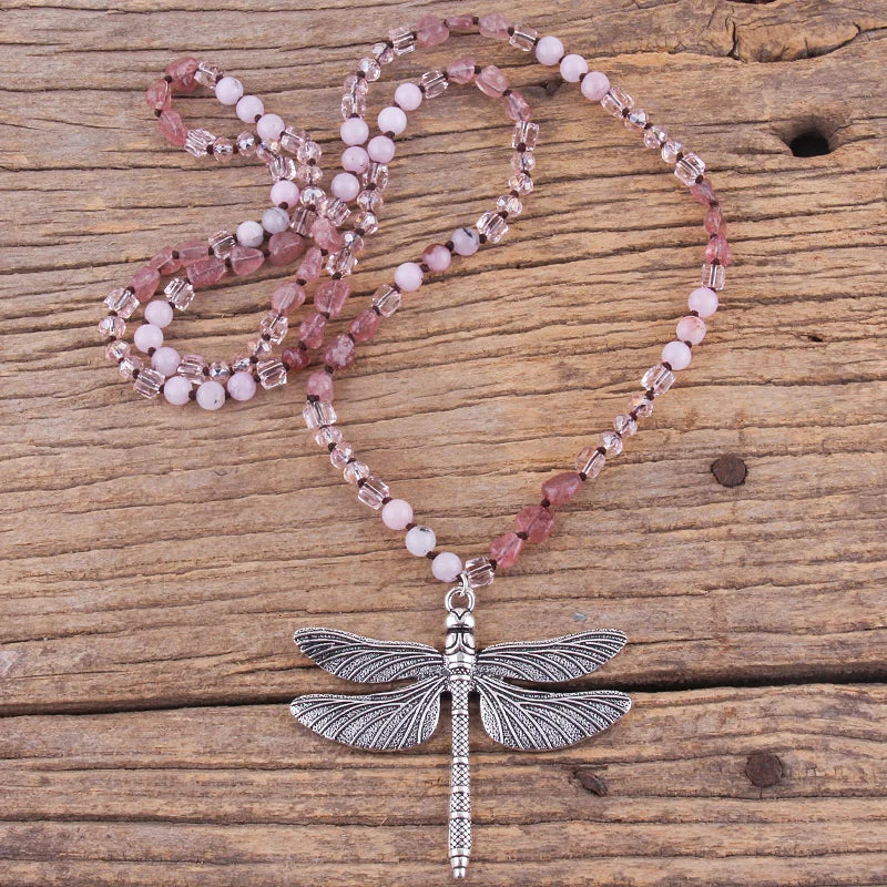 Beaded necklace with a dragonfly pendant on a wooden surface