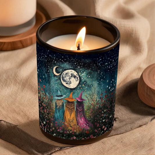 Candle in a decorative container with witch design and flame on a textured surface