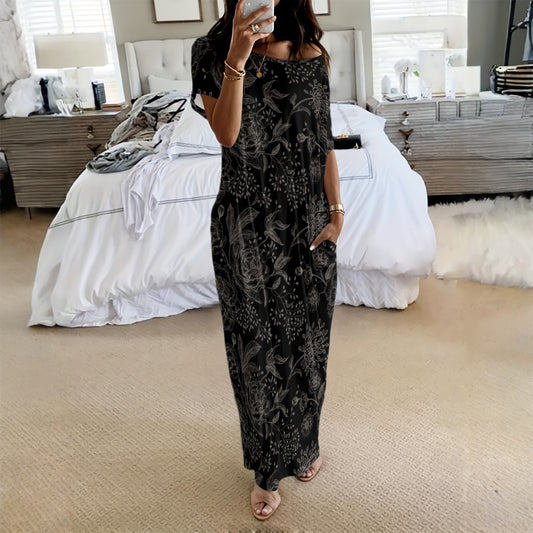 Woman wearing a black floral dress in a bedroom setting