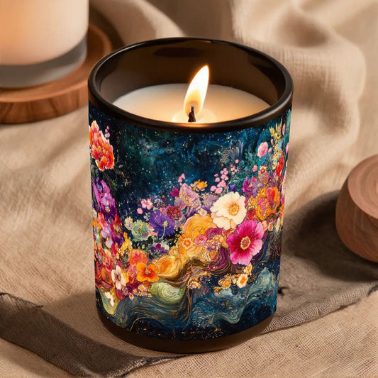 Candle in a colorful floral container on a textured surface