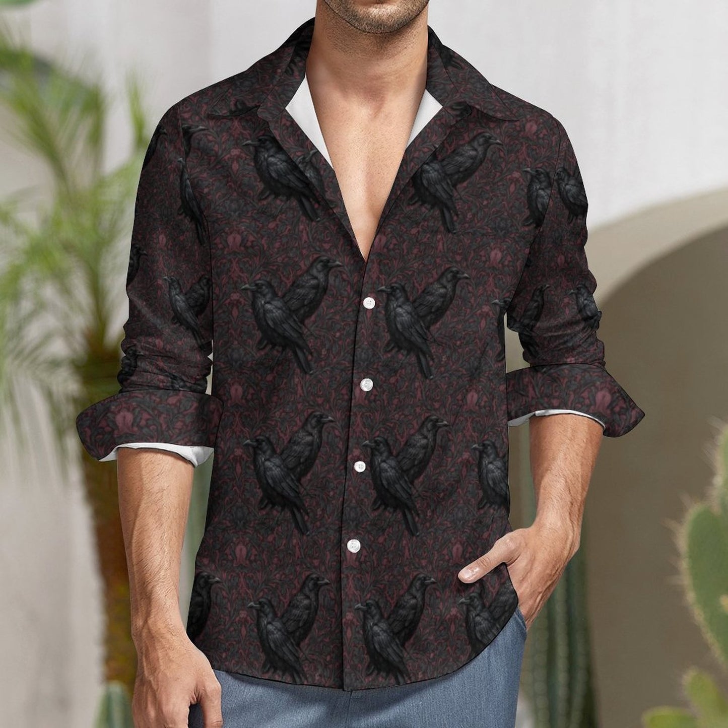 Man wearing a dark patterned shirt with black birds in an outdoor setting