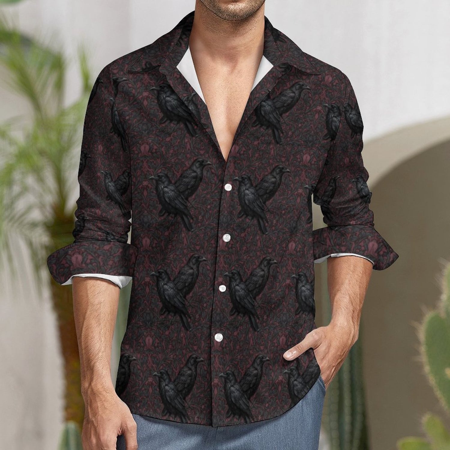 Man wearing a dark patterned shirt with black birds in an outdoor setting