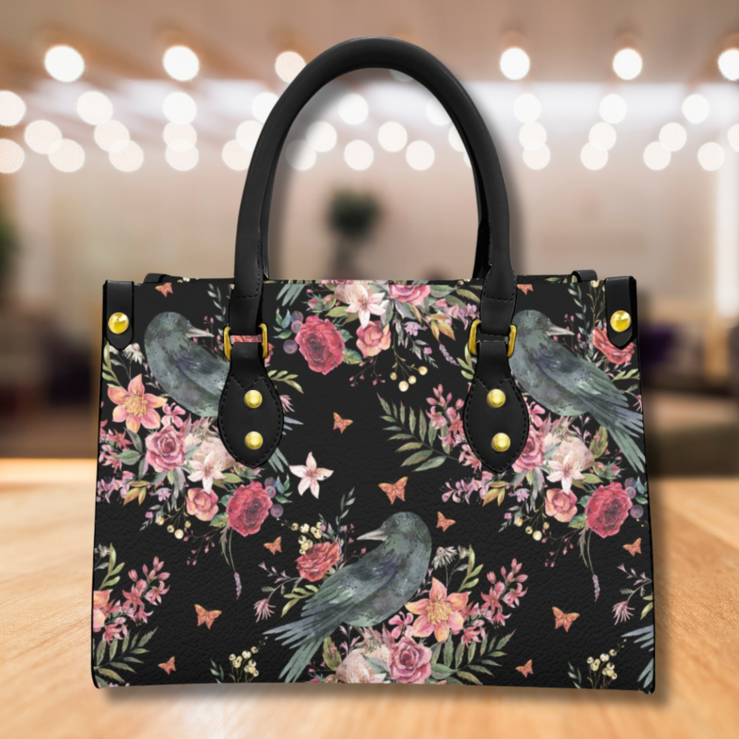 Handbag with floral and bird design on a wooden surface with blurred background