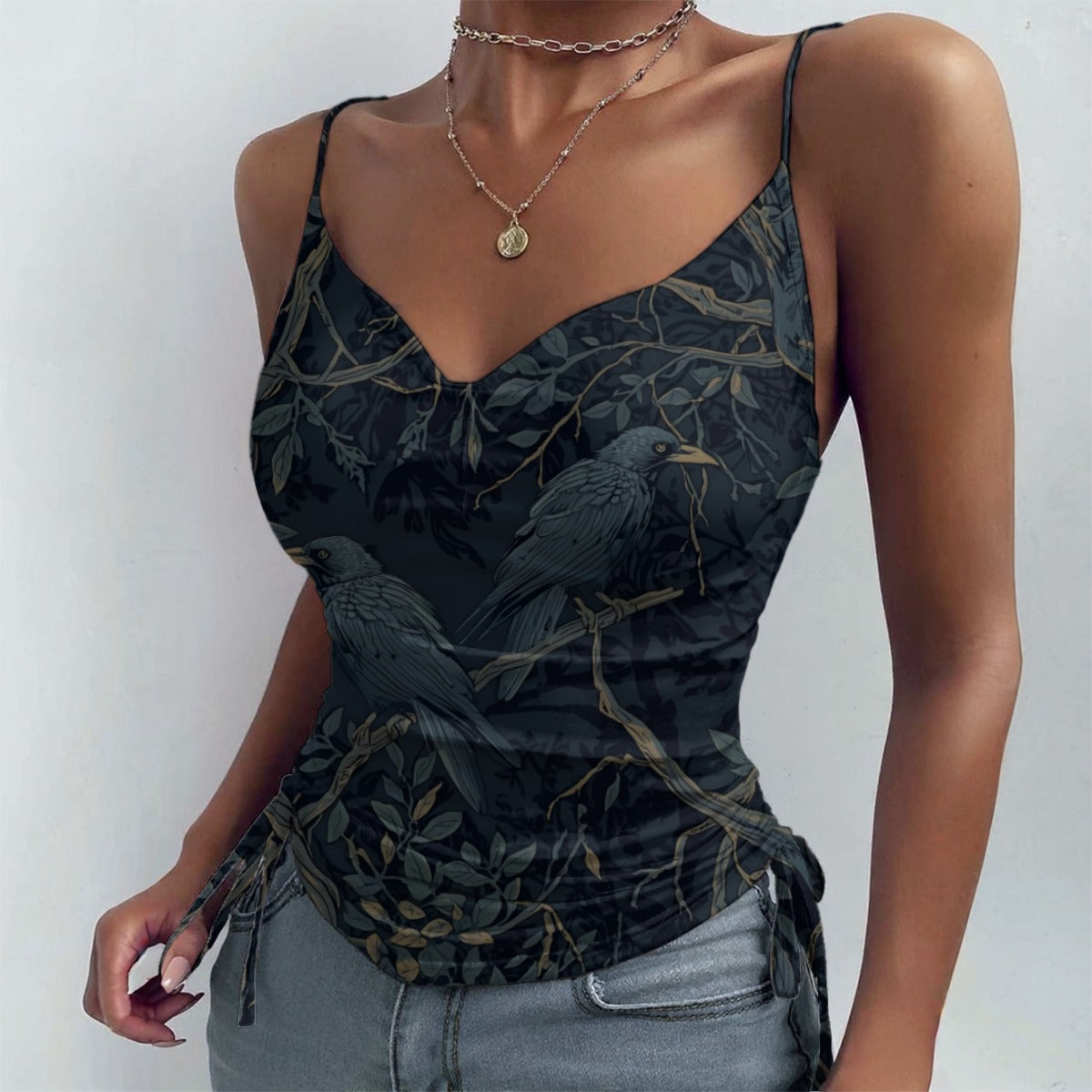 Woman wearing a black tank top with bird and leaf pattern against a white background