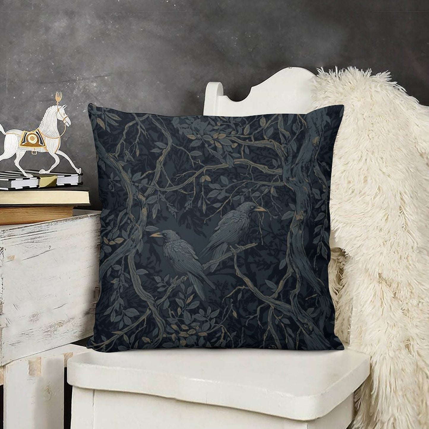 Decorative pillow with bird and branch pattern on a white chair against a dark background