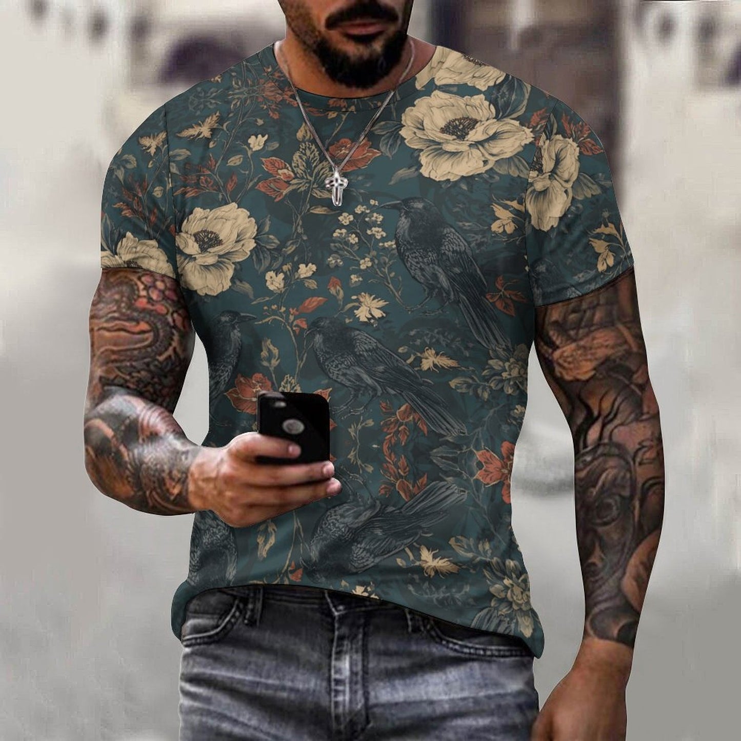 Man wearing a floral-patterned t-shirt with tattoos holding a phone.