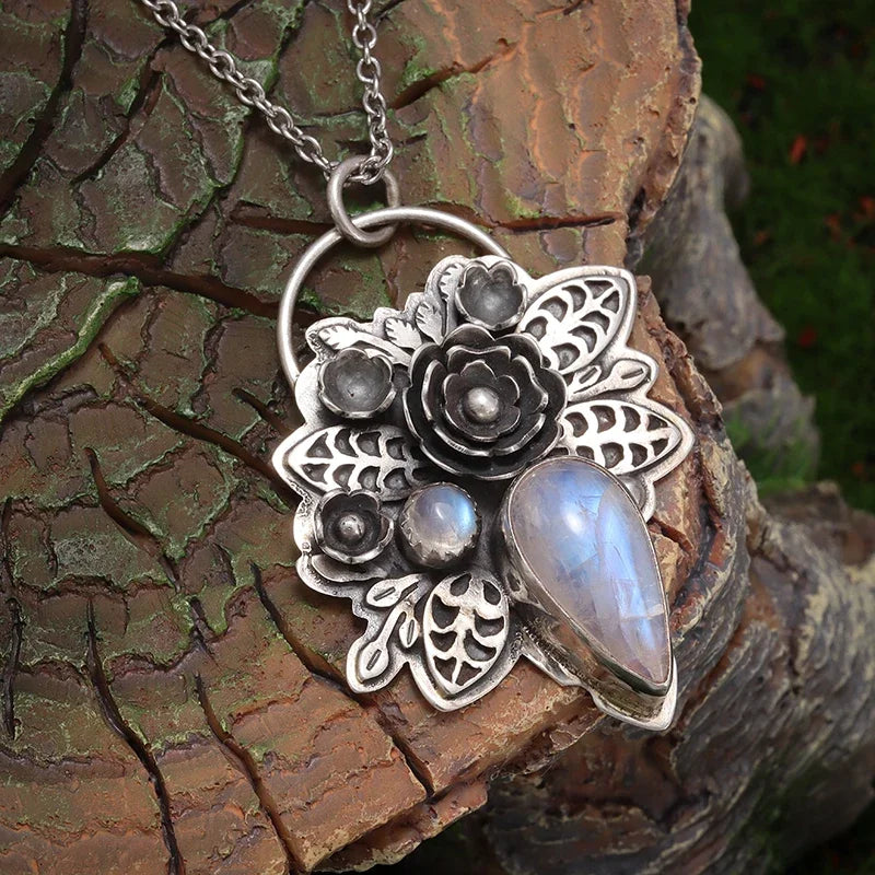 Silver floral pendant with gemstones on a wooden surface