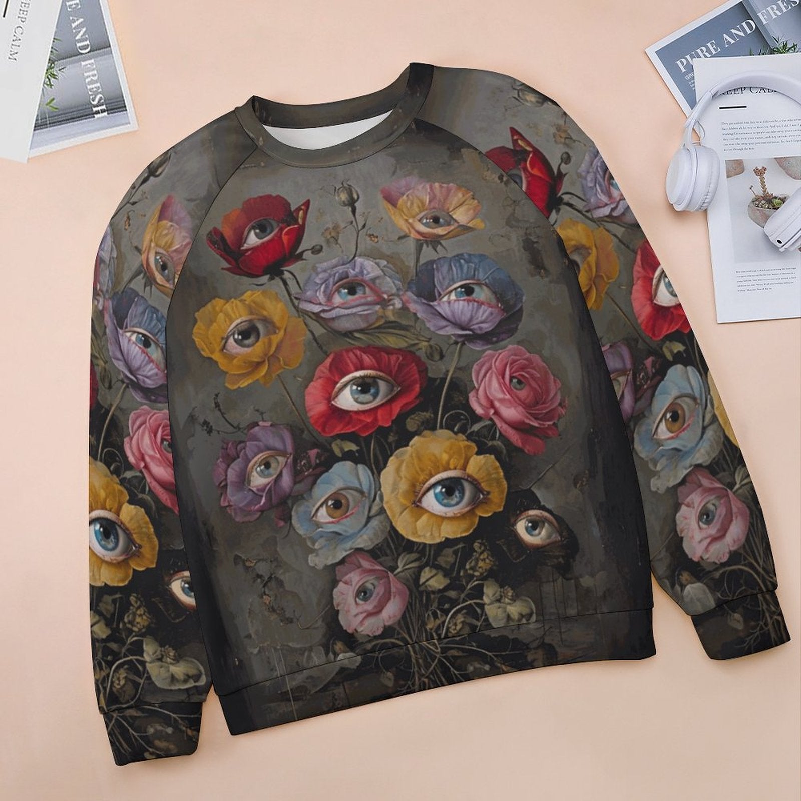 Sweatshirt with floral and eye design on a beige surface