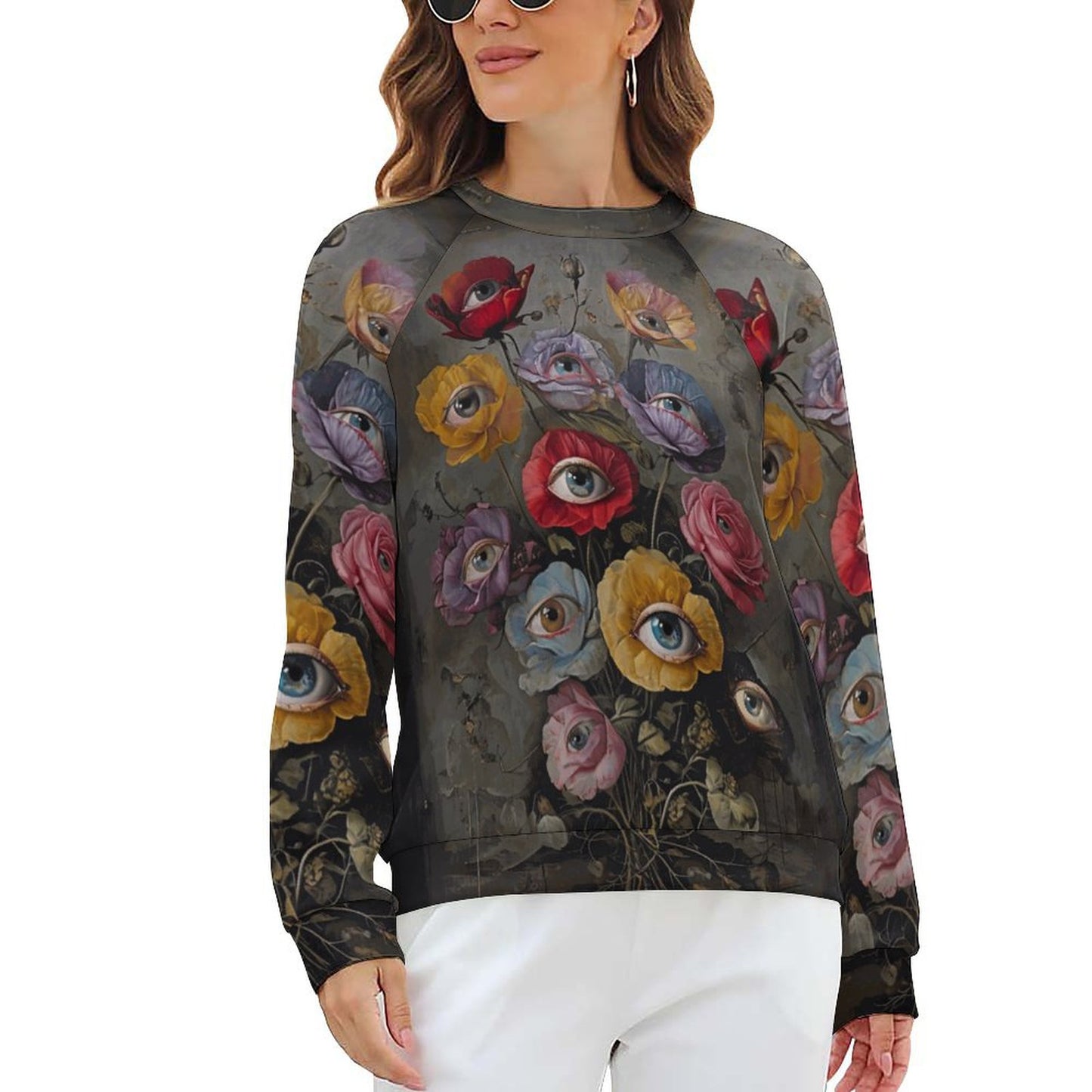 Woman wearing a sweater with floral and eye design on a white background