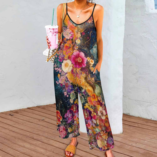 Person wearing a colorful floral jumpsuit holding a drink.