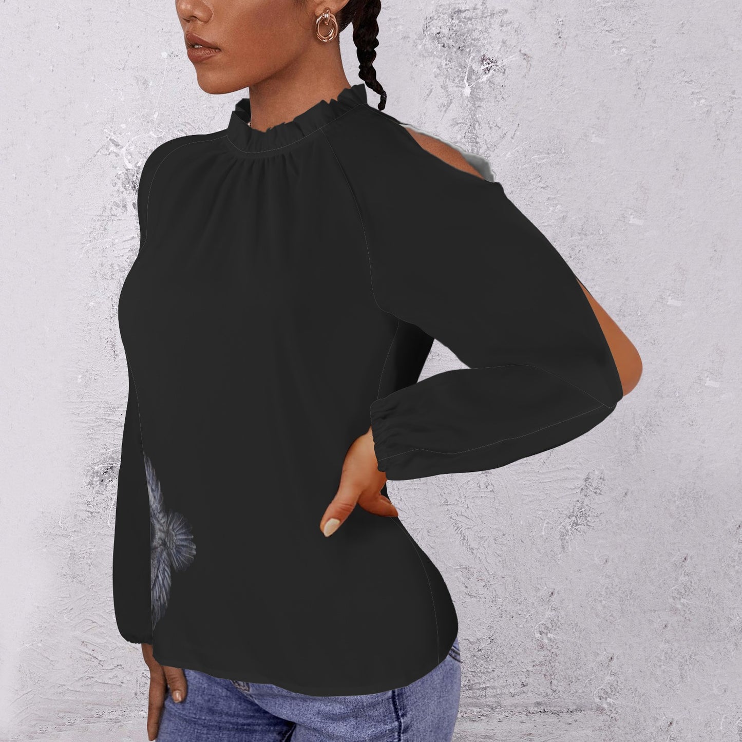 Woman wearing a black long-sleeve top with a textured gray background