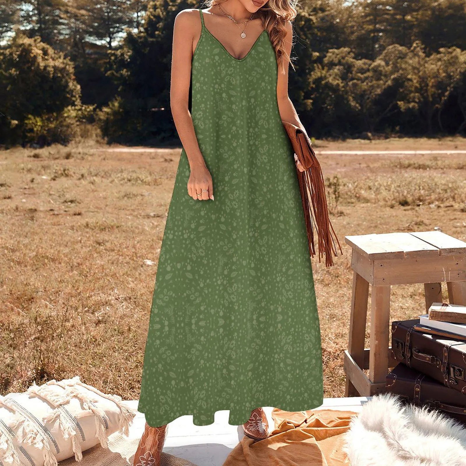 Woman in a green dress standing outdoors with nature in the background