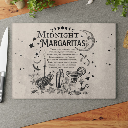 Cutting board with 'Midnight Margaritas' design on a gray surface with a knife.