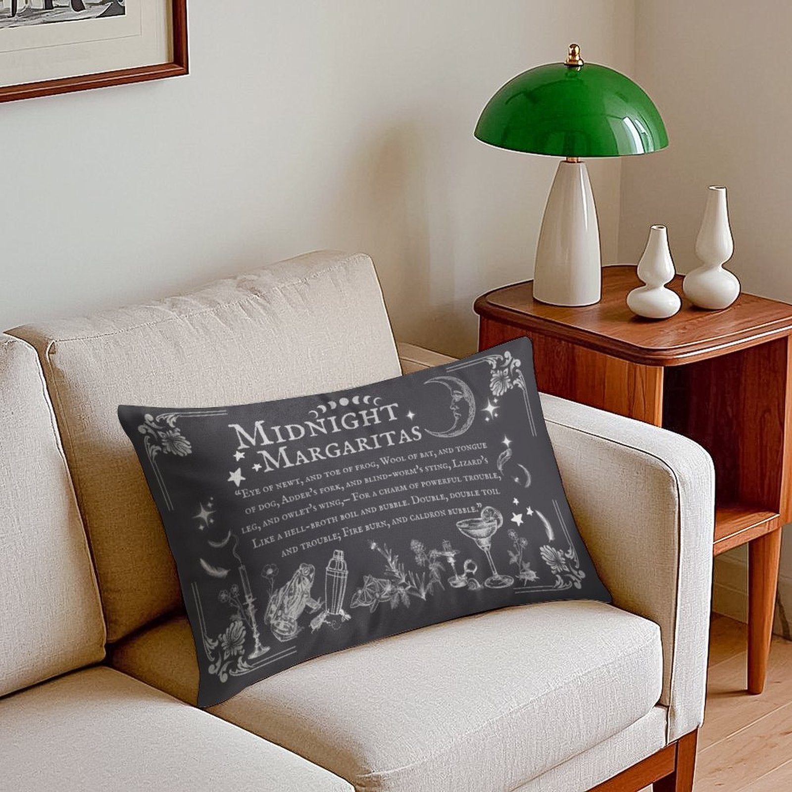 Decorative pillow with 'Midnight Margaritas' text on a beige sofa with a green lamp and wooden side table in the background.
