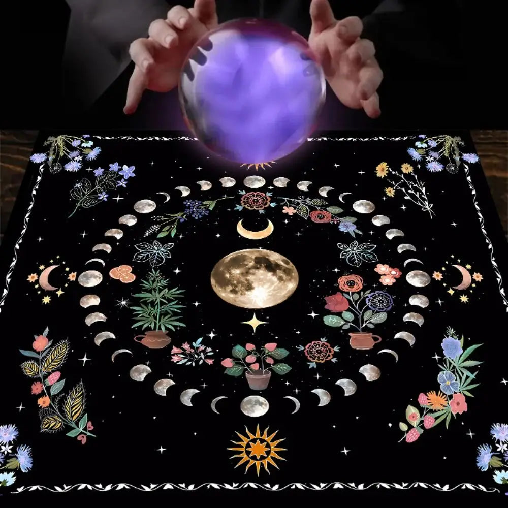 Person holding a glowing crystal ball over a black cloth with astrological designs.