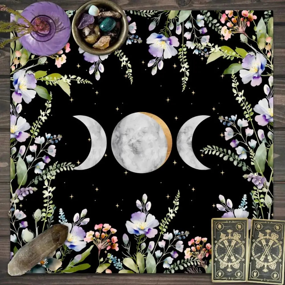 Decorative mat with moon phases, flowers, and a tarot card on a dark background