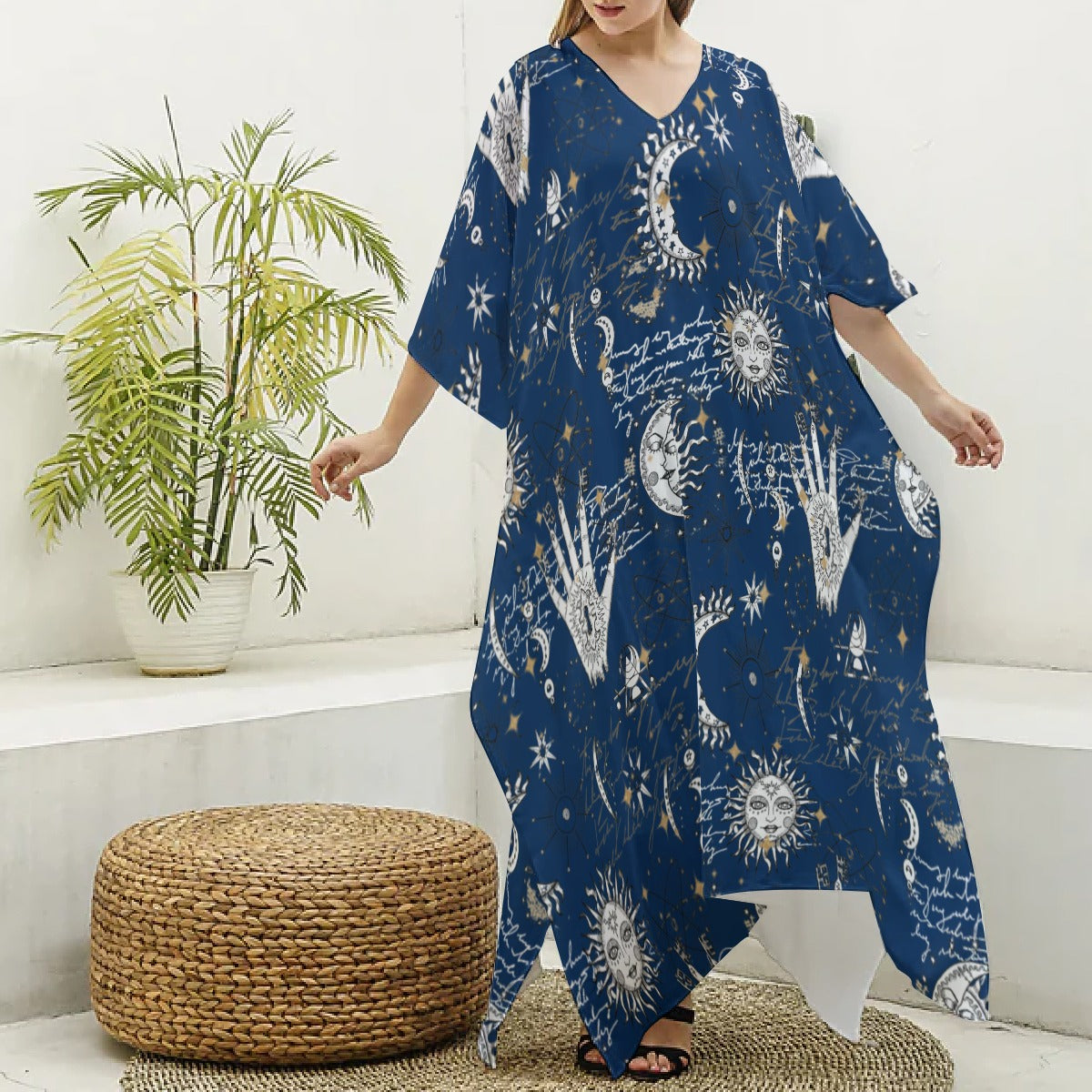 Person wearing a blue dress with celestial patterns in a room with a plant and woven ottoman.