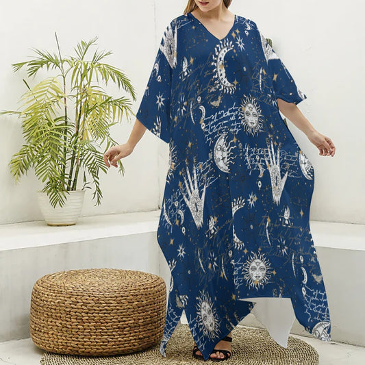 Person wearing a blue dress with celestial patterns in a room with a plant and woven ottoman.