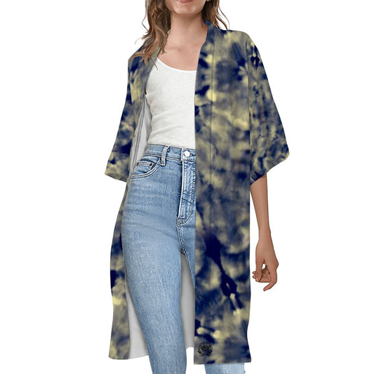 A woman wearing a navy tie-dye short-sleeve cape with white inner lining, paired with blue jeans and a white top.