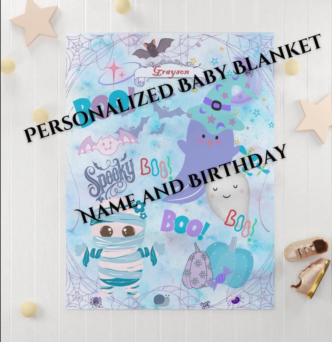 Personalized baby blanket with Halloween-themed characters on a light wooden background.
