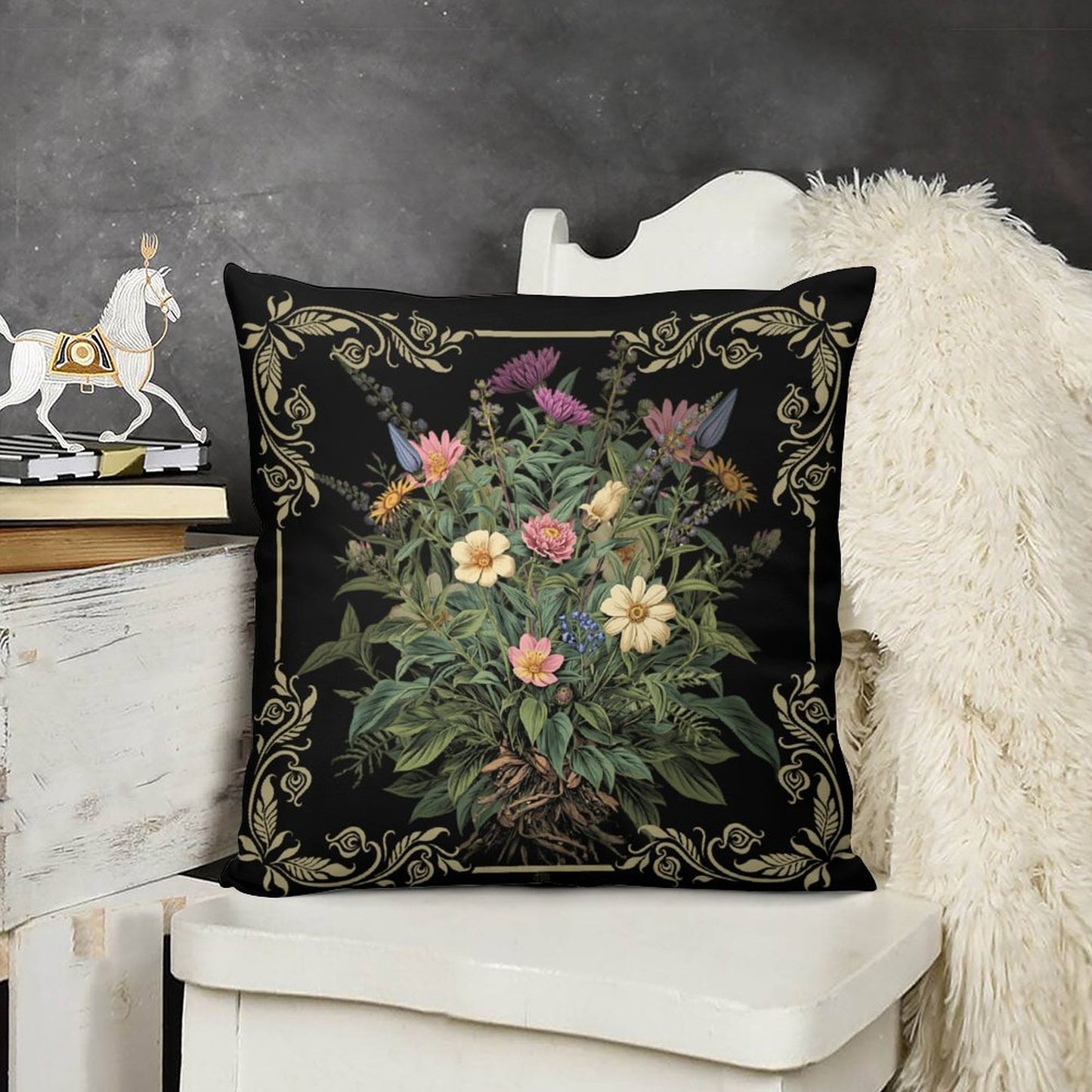 Decorative pillow with floral design on a black background, placed on a white chair.