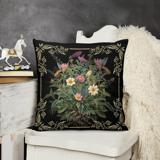 Decorative pillow with floral design on a black background, placed on a white chair.