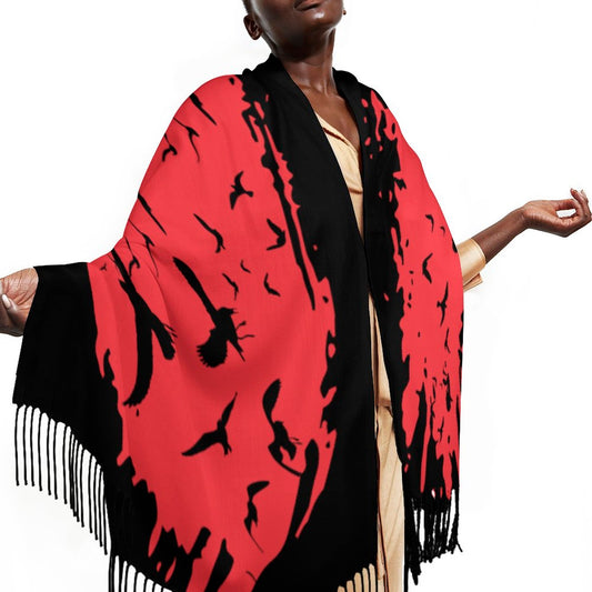 Person wearing a red and black patterned scarf with fringes on a white background
