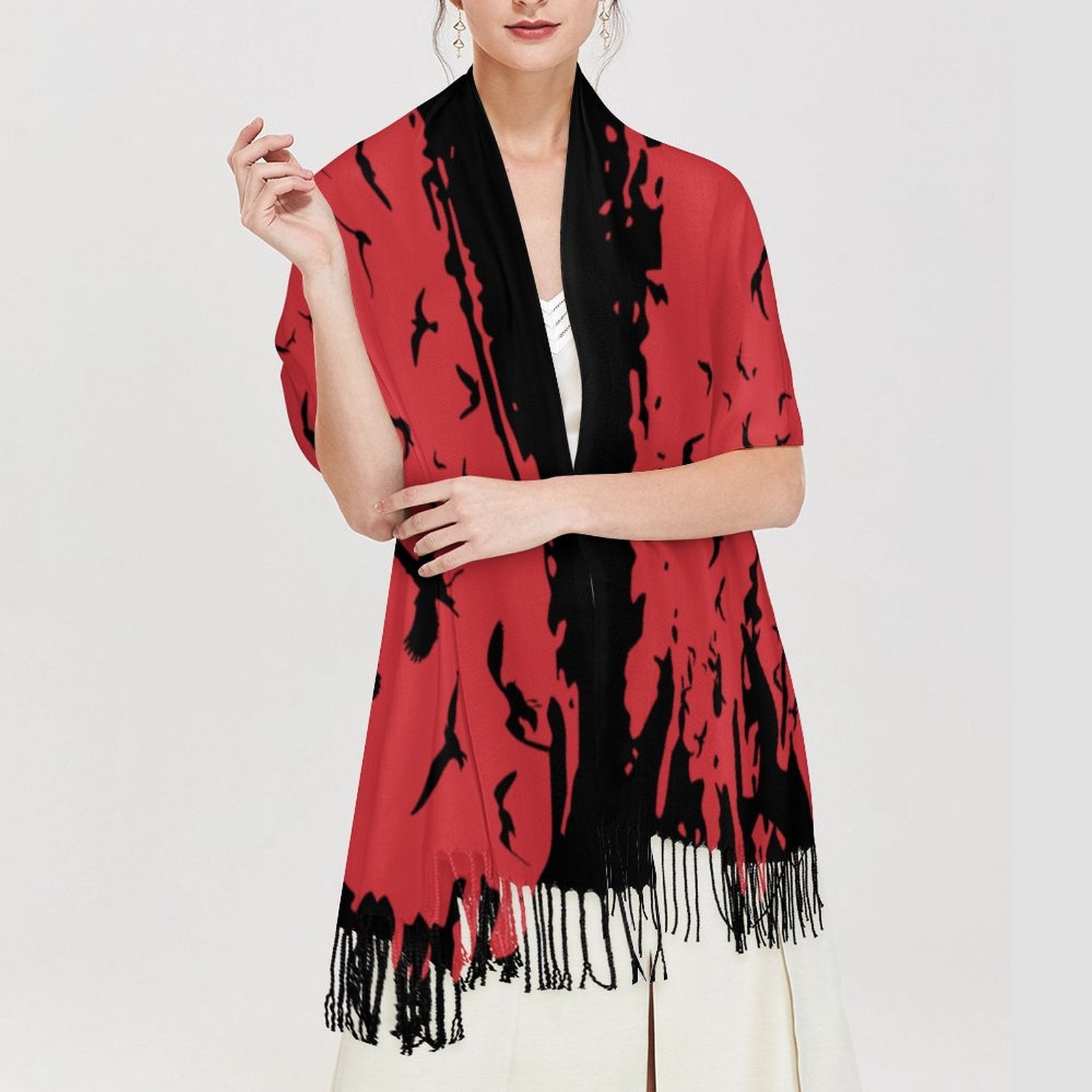 Woman wearing a red and black patterned scarf with fringe on a white background