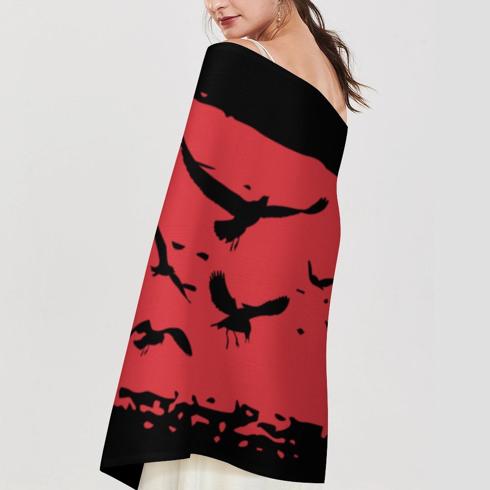 Woman wearing a strapless dress with black and red bird pattern on a white background