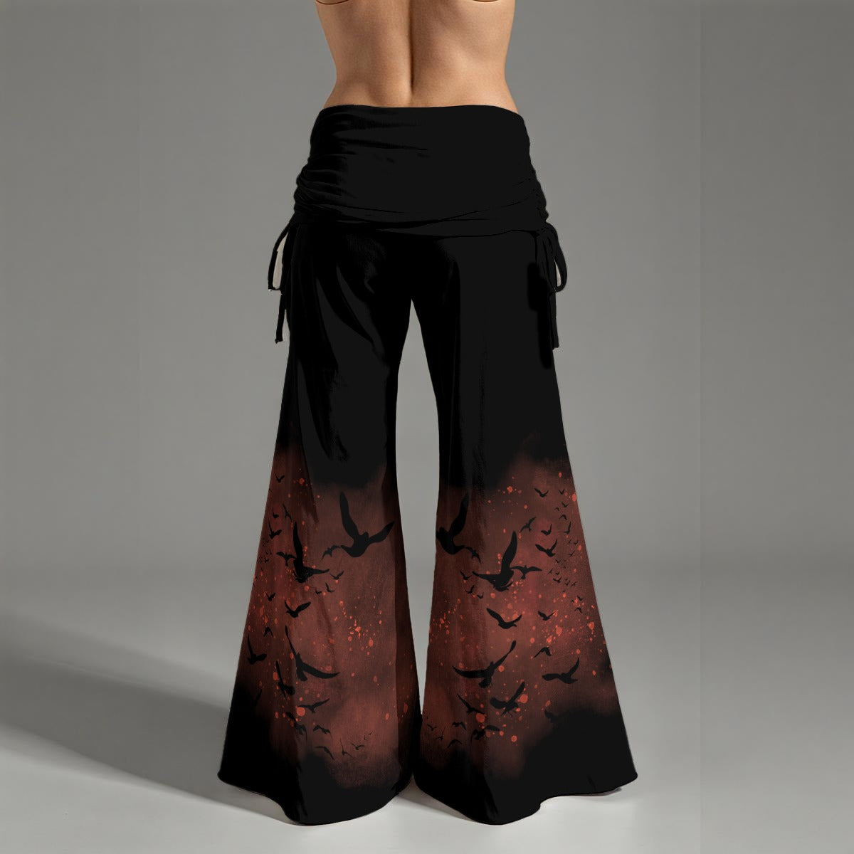 Black and red gradient pants with bird pattern on a gray background